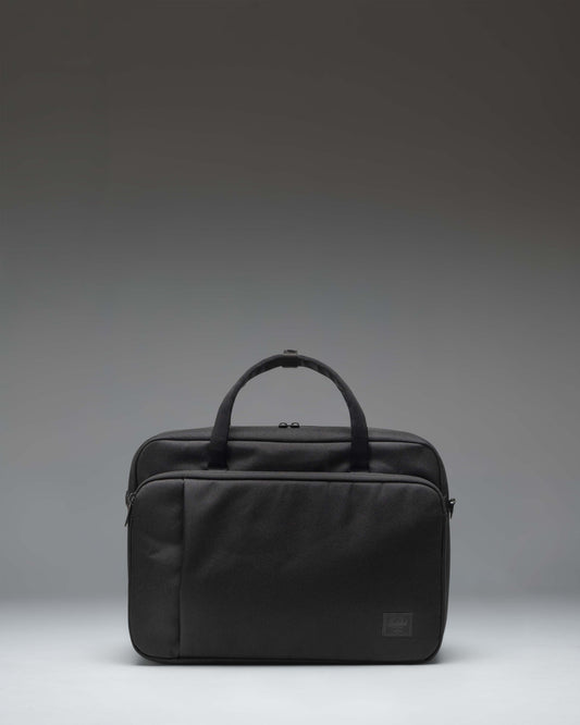 Herschel Supply Co. Gibson Messenger Tech bag in black, showing the front view with dual top handles, a removable shoulder strap, and front pockets.