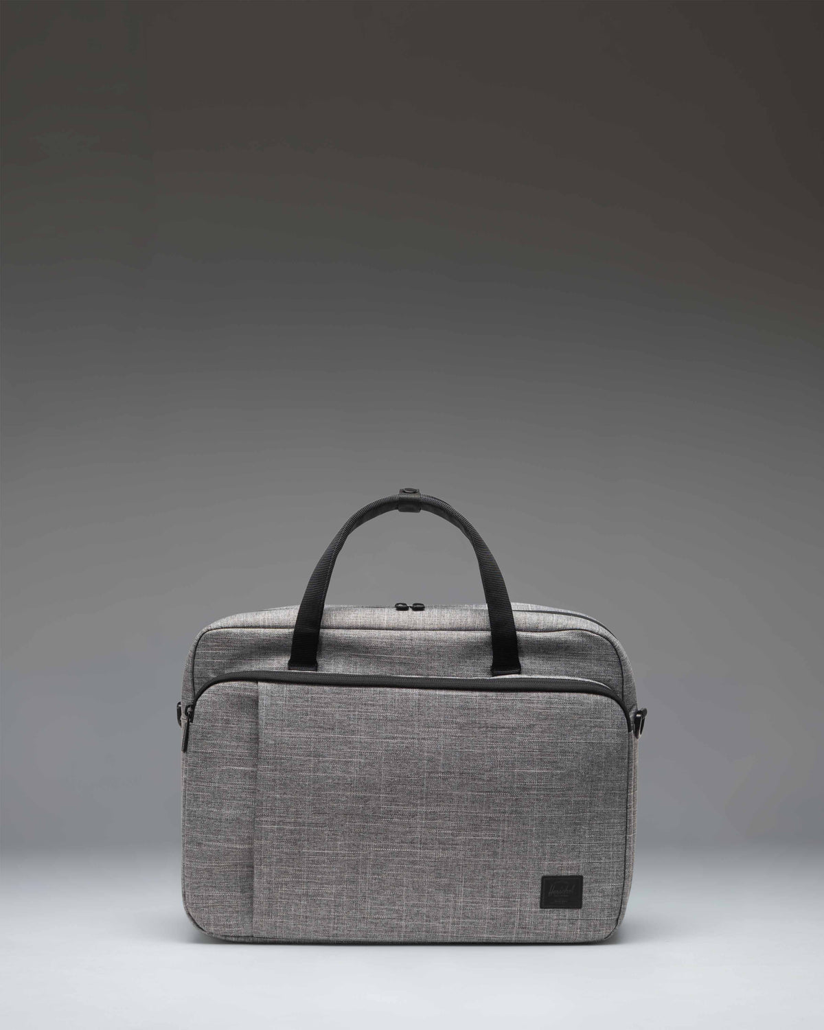 Herschel Supply Co. Gibson Messenger Tech bag in Raven Crosshatch grey, showing a front view with dual top handles and a zippered pocket.