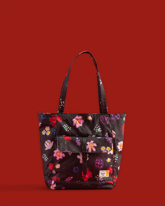 Herschel Supply Co. LEGO Retreat Tote bag in Falling Florals print featuring a black background with vibrant pink, yellow, and green flowers.