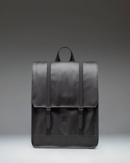 Herschel Survey Backpack in black, showing the front view with its classic square silhouette and dual strap closures.