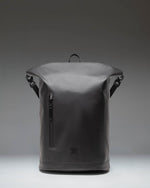 Herschel Supply Co Roll Top Backpack in black shown from an angled front view, highlighting its sleek design and roll-top closure.
