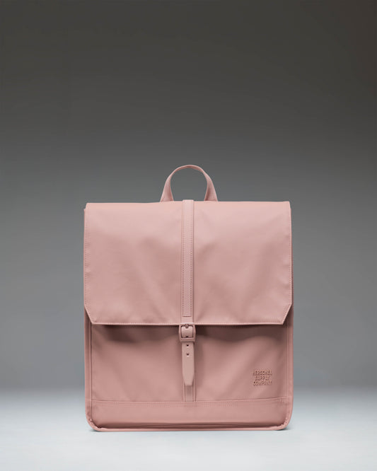 Herschel Supply Co. City Backpack in Ash Rose, a minimalist pink daily backpack with a clean design, single strap closure, and front storage sleeve.