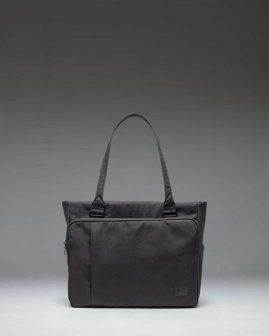 Black Herschel Supply Co. Kaslo Tote Tech bag shown from a front perspective, highlighting its clean, functional design.