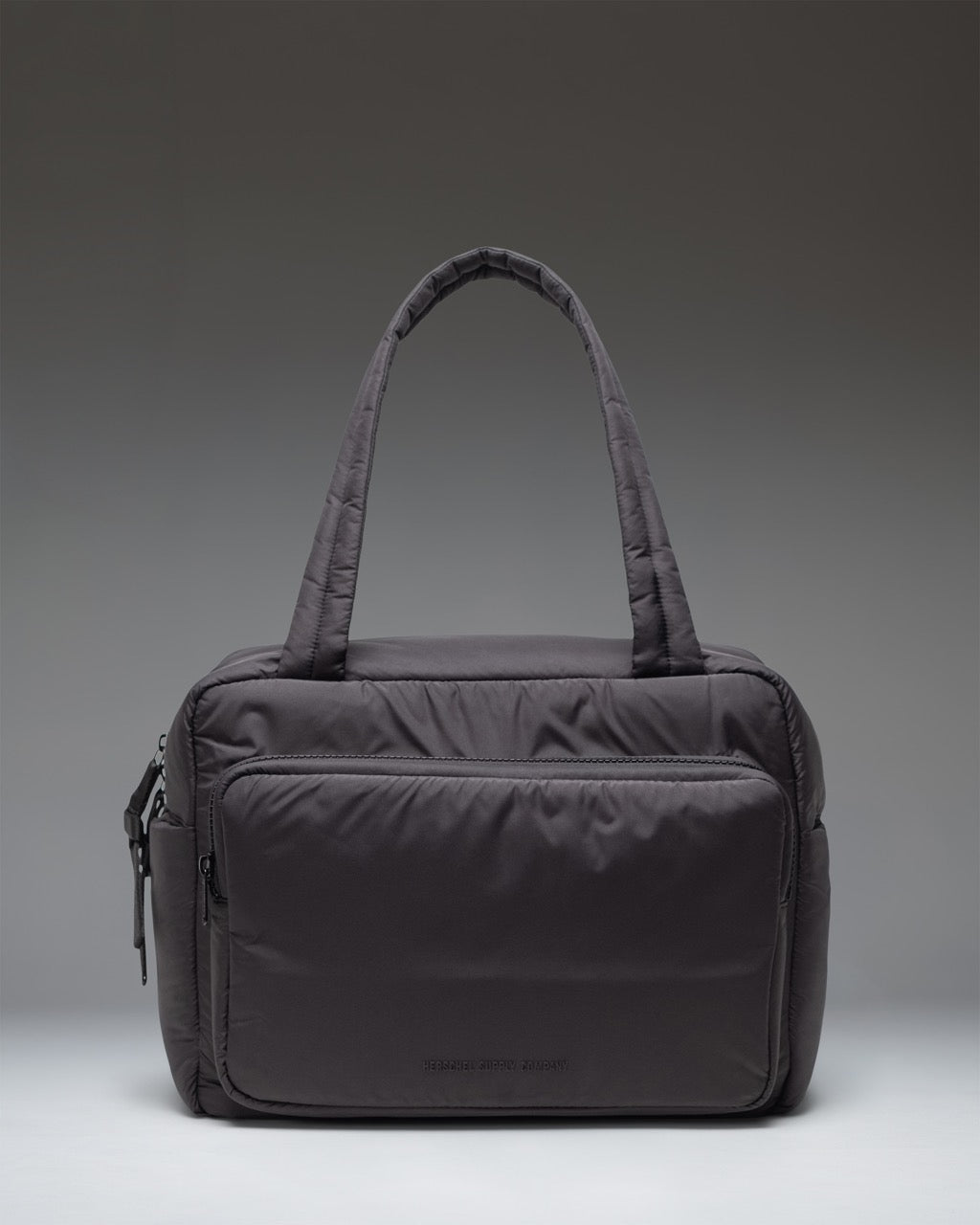 Herschel Supply Co. Cloudform Duffle bag in black, showing the clean, minimalist exterior design and durable carrying straps.