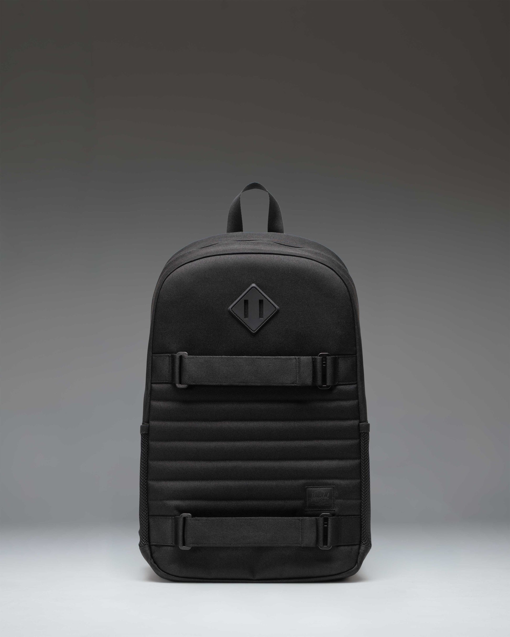 Herschel Supply Co. Fleet Skate Backpack in black, featuring an open front pocket with adjustable skate straps and a classic woven label.