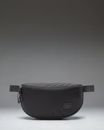 Herschel Supply Co. Kaine Hip Pack in black, featuring a front zippered pocket and an adjustable strap with a buckle.