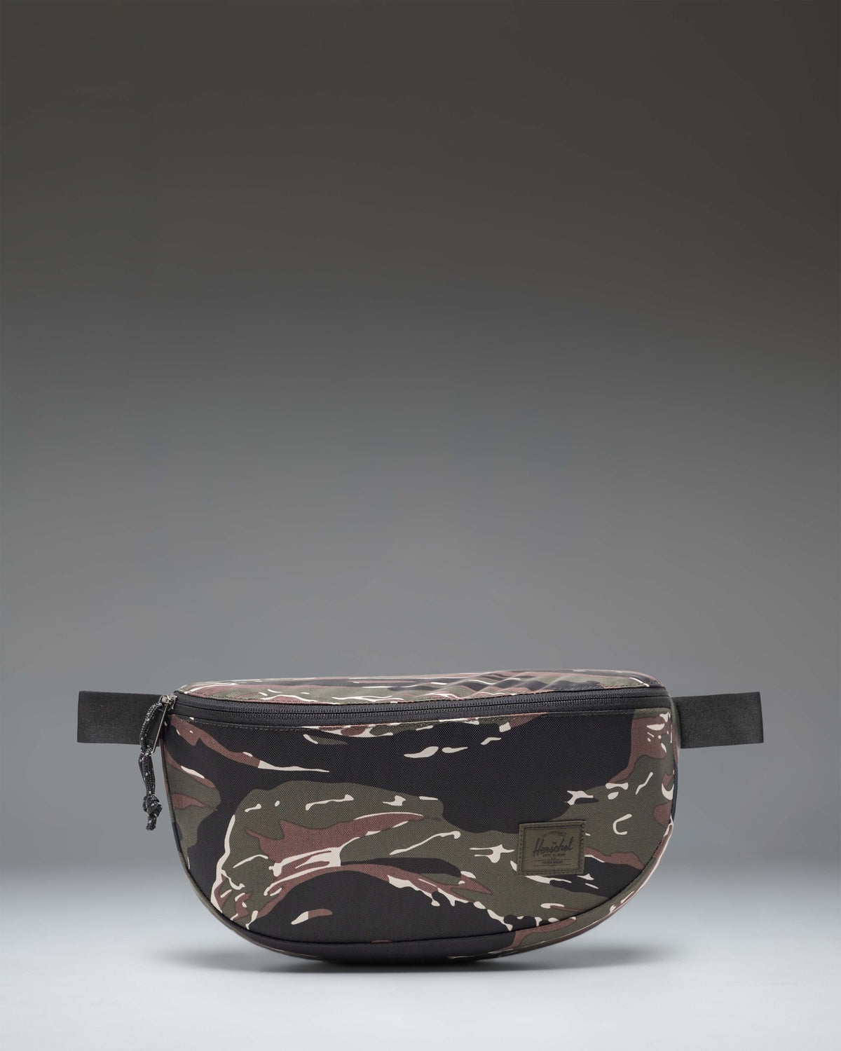 Herschel Supply Co. Kaine Hip Pack in Tiger Camo, showing the front view with zipper details and adjustable strap.