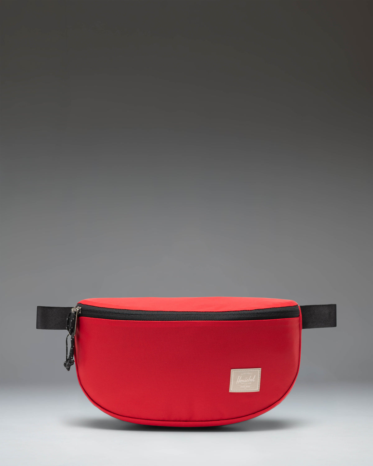 Herschel Supply Co Kaine Hip Pack in Barbados Cherry red, featuring a front zippered pocket and adjustable strap.
