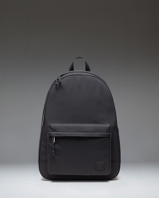 Front view of the Herschel Classic XL Backpack in black, featuring a zippered main compartment and front pocket with the signature woven label.