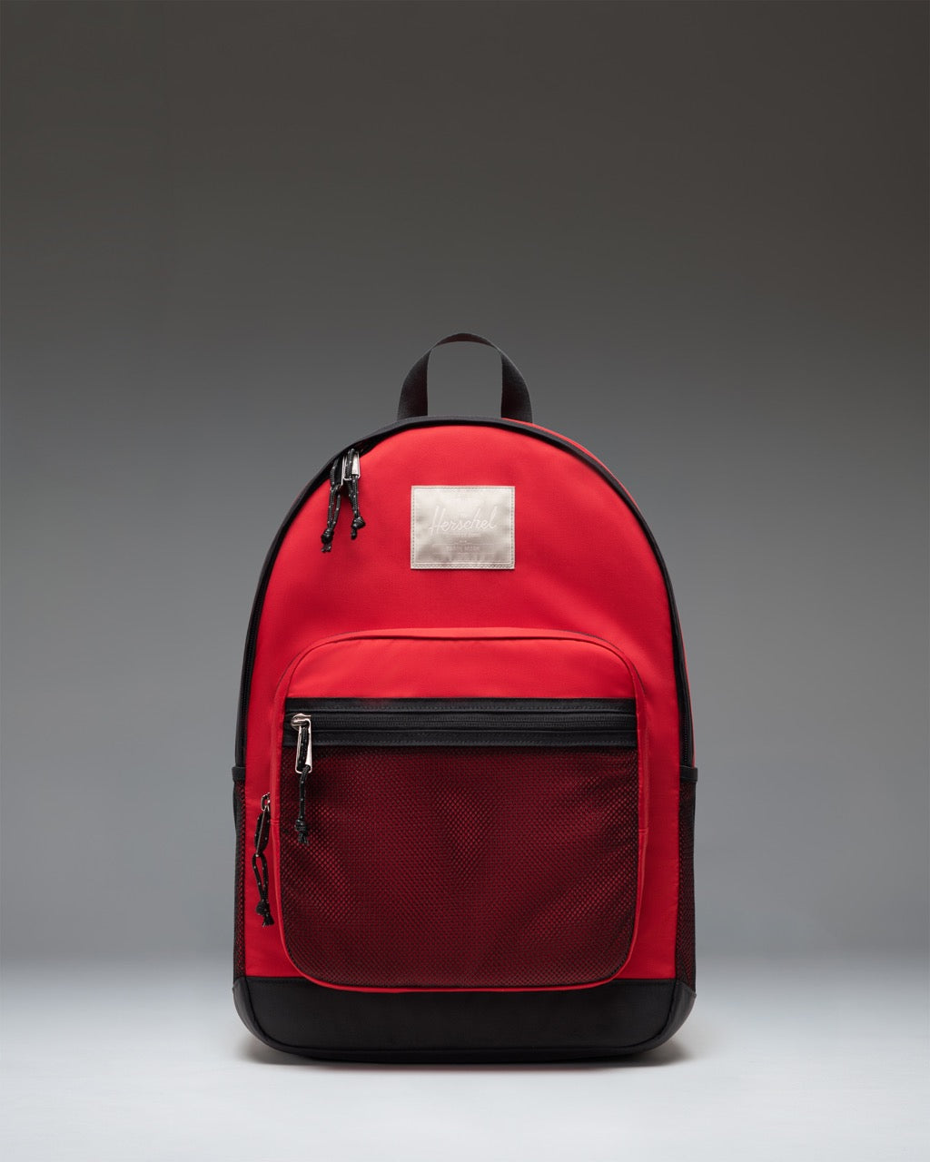 Herschel Supply Co. Kaine Backpack in Barbados Cherry red, showing the front view with zipper pockets and classic logo patch.