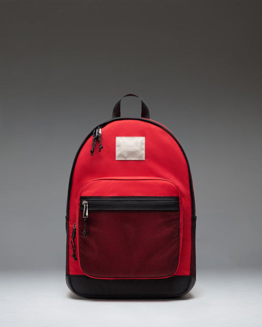 Herschel Supply Co. Kaine Backpack in Barbados Cherry red, showing the front view with zipper pockets and classic logo patch.