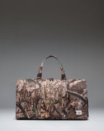 Herschel Supply Co Realtree Novel Duffle bag in Realtree APX Camo pattern, featuring a side shoe compartment.