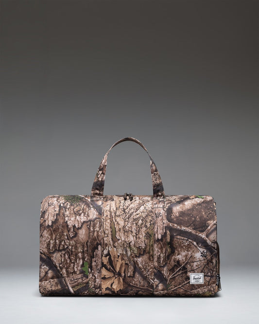 Herschel Supply Co Realtree Novel Duffle bag in Realtree APX Camo pattern, featuring a side shoe compartment.