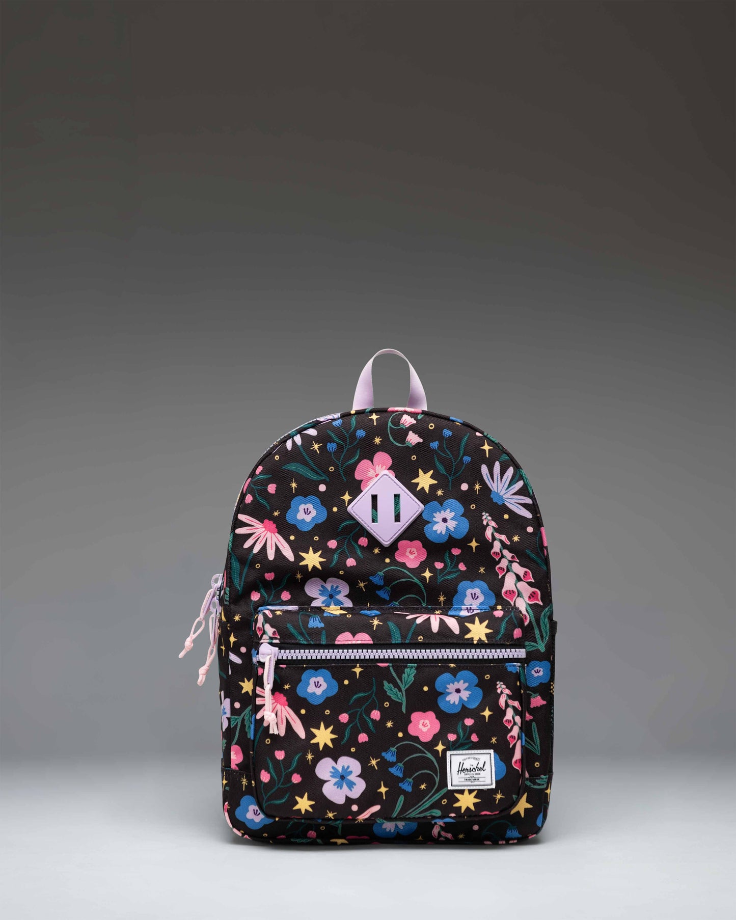 Herschel Heritage Kids Backpack in Enchanted Garden, featuring a vibrant floral pattern on a dark background with a front pocket.