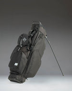 Black Herschel Watt Stand Golf Bag featuring a 5-way top organizer, multiple zippered storage pockets, and a durable fabric construction.