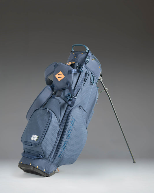 Herschel Watt Stand Bag in Navy, showcasing a full view of the golf stand bag with its multiple zippered pockets and sturdy legs.