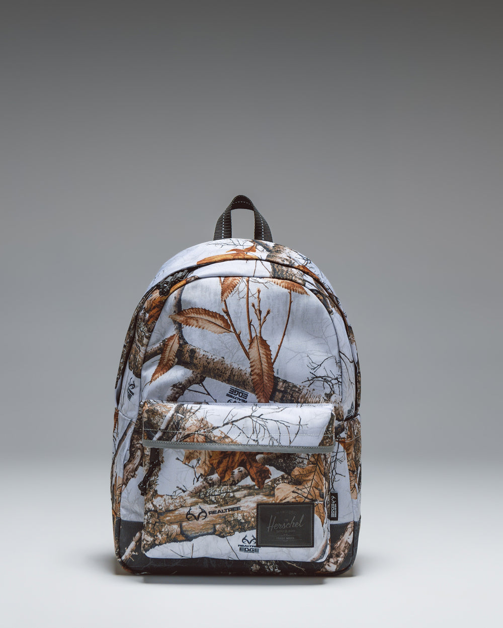 Herschel Classic Backpack in Realtree Edge Camo White/Black, showcasing the tree branch and leaf camouflage pattern.