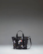Black Peanuts Herschel Heritage Small Tote bag featuring a Snoopy and Woodstock graphic print on the front pocket.