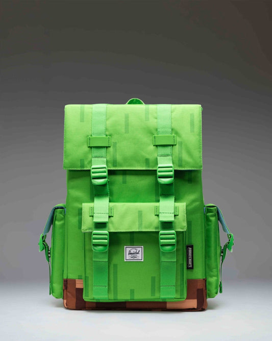 Minecraft Herschel Little America Cube Backpack in the Grass Block pixelated green and brown pattern, shown from the front.