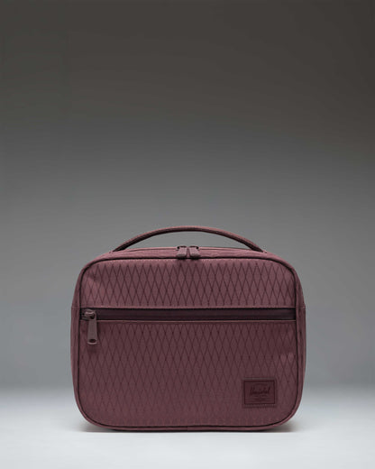 Herschel Supply Co. Pop Quiz Lunch Box in Huckleberry Diamond, featuring a vibrant purple and blue geometric pattern with a front storage pocket.