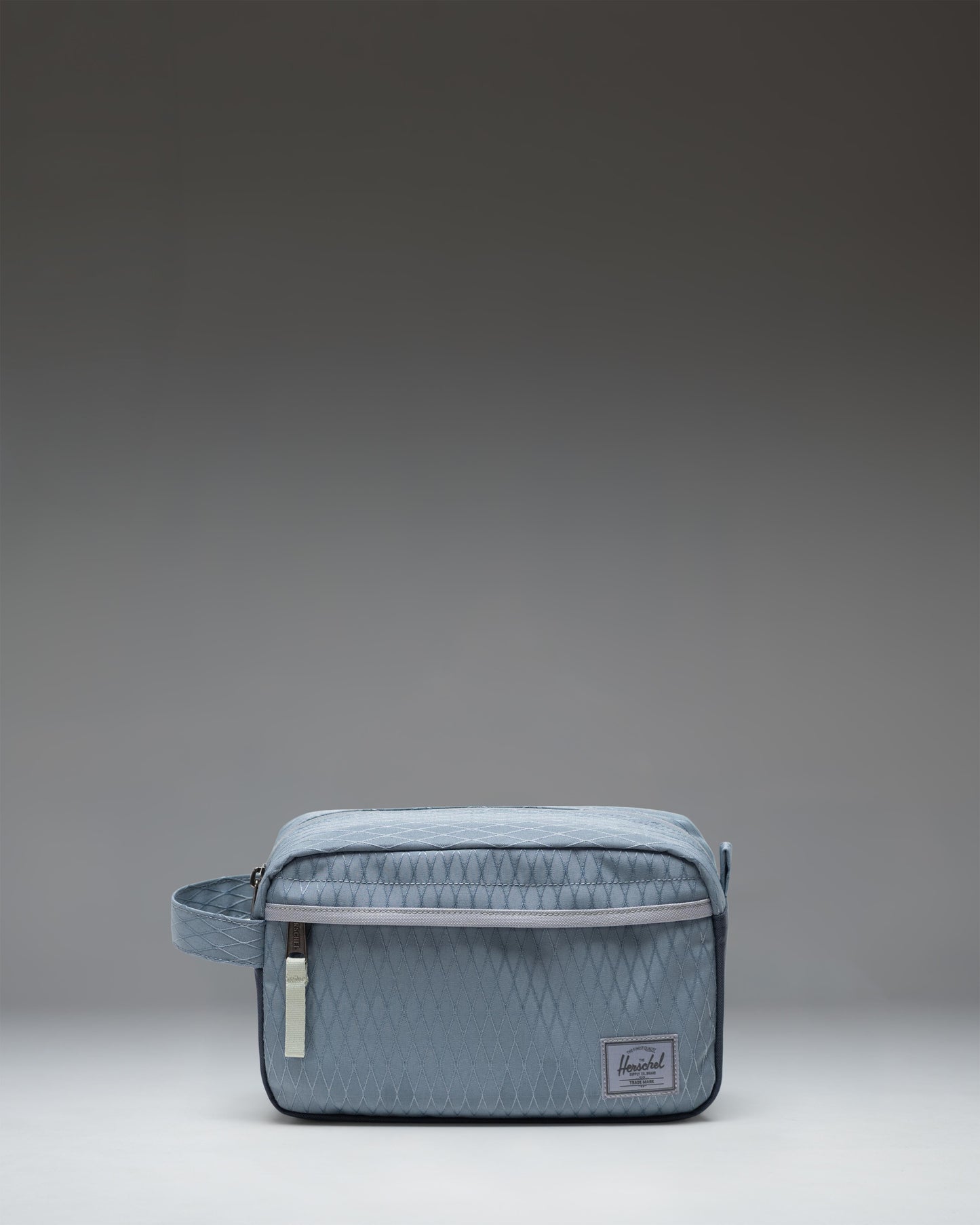 Herschel Supply Co. Chapter Travel Kit in Blue Mirage Diamond and Sea Storm pattern, featuring a side handle and front zippered pocket.