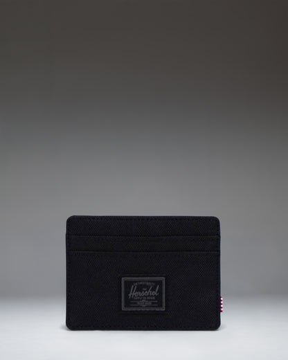 Black Tonal Herschel Supply Co. Charlie Cardholder wallet featuring a minimalist design with multiple card slots and a central storage sleeve.
