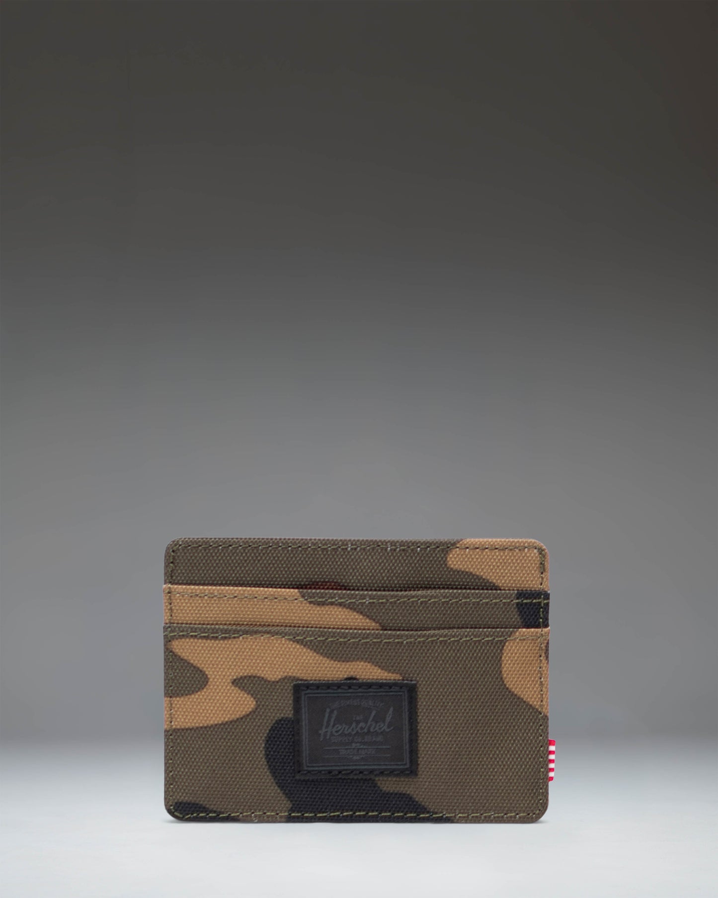 Herschel Supply Co. Charlie Cardholder in Woodland Camo with a black label, showing the slim wallet design.