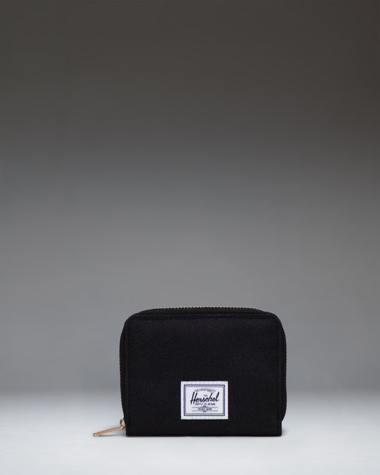 Herschel Supply Co Tyler Wallet in black, displaying a classic zippered design with the signature woven label on the front.