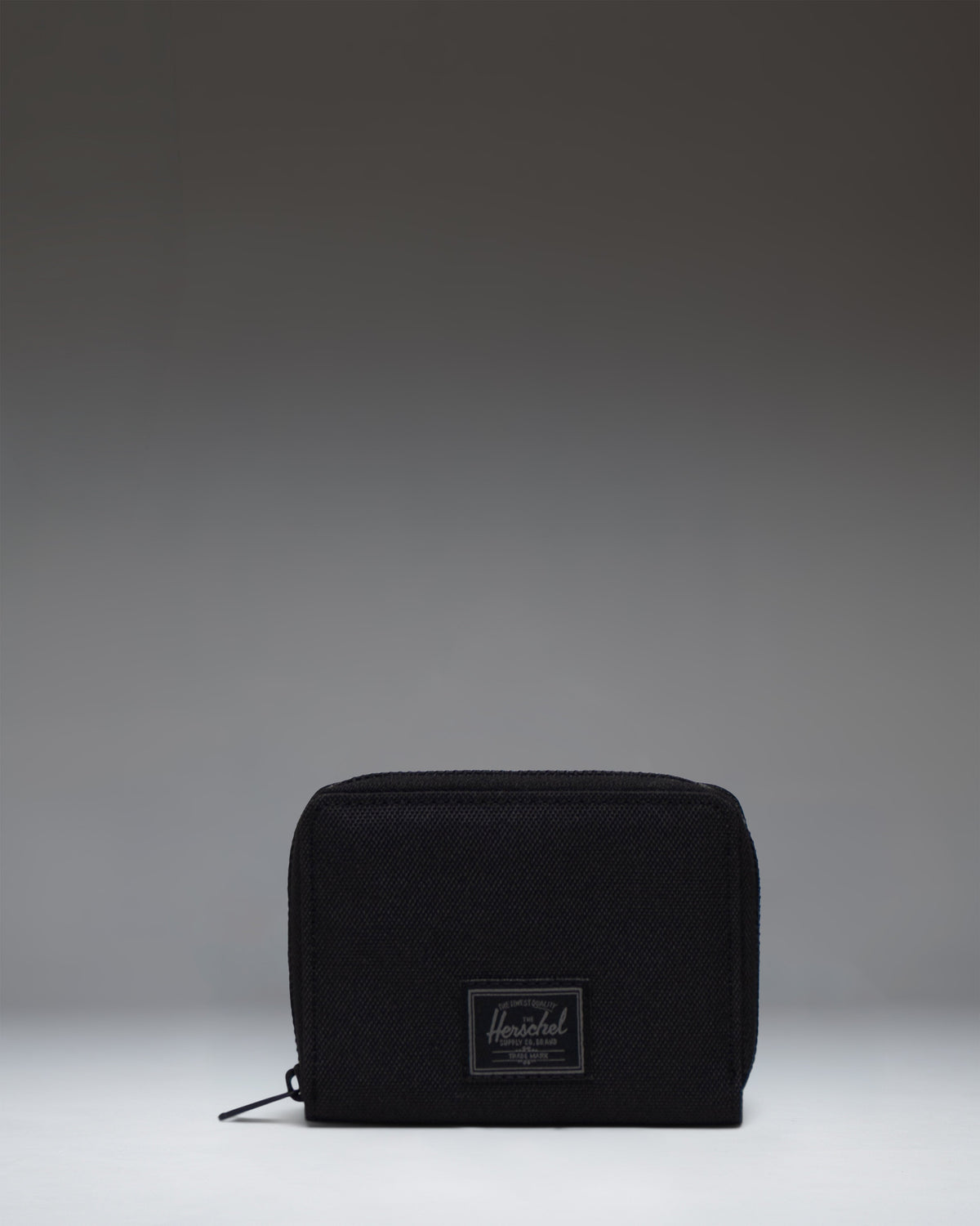 Herschel Supply Co Tyler Wallet in Black Tonal, showing the front view of the compact, zippered wallet with a clean, classic design.