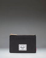 Herschel Supply Co. Oscar Cardholder in black, showing a sleek, compact design with multiple card slots and the classic woven brand label.