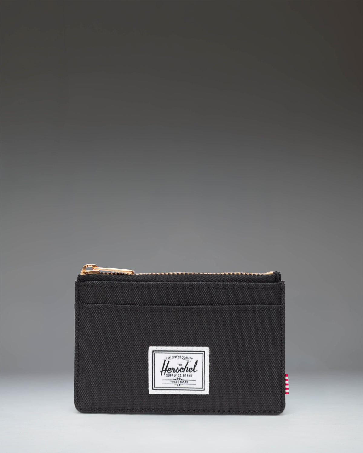 Herschel Supply Co. Oscar Cardholder in black, showing a sleek, compact design with multiple card slots and the classic woven brand label.