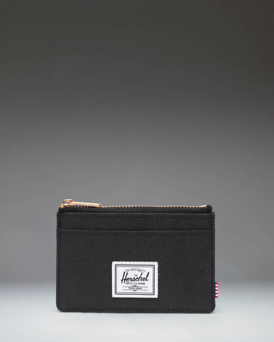 Herschel Supply Co. Oscar Cardholder in black, showing a sleek, compact design with multiple card slots and the classic woven brand label.