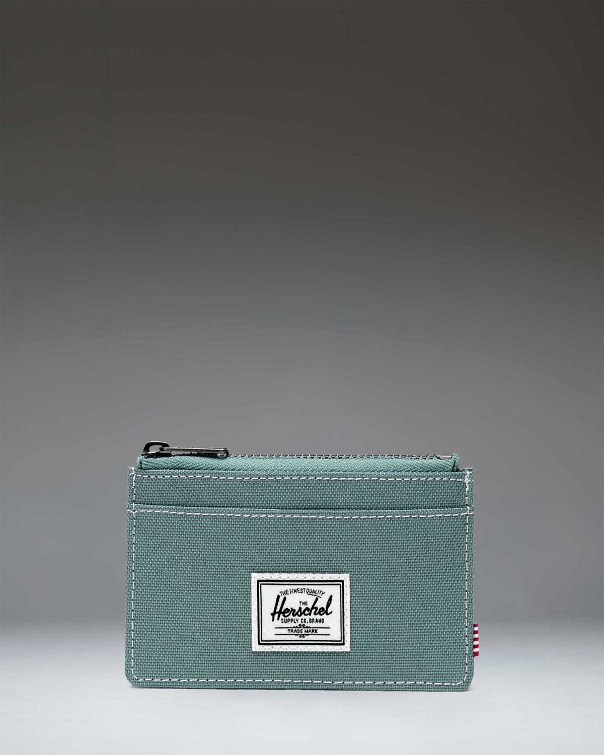 Herschel Supply Co. Oscar Cardholder wallet featuring external card slots and a zippered main compartment.