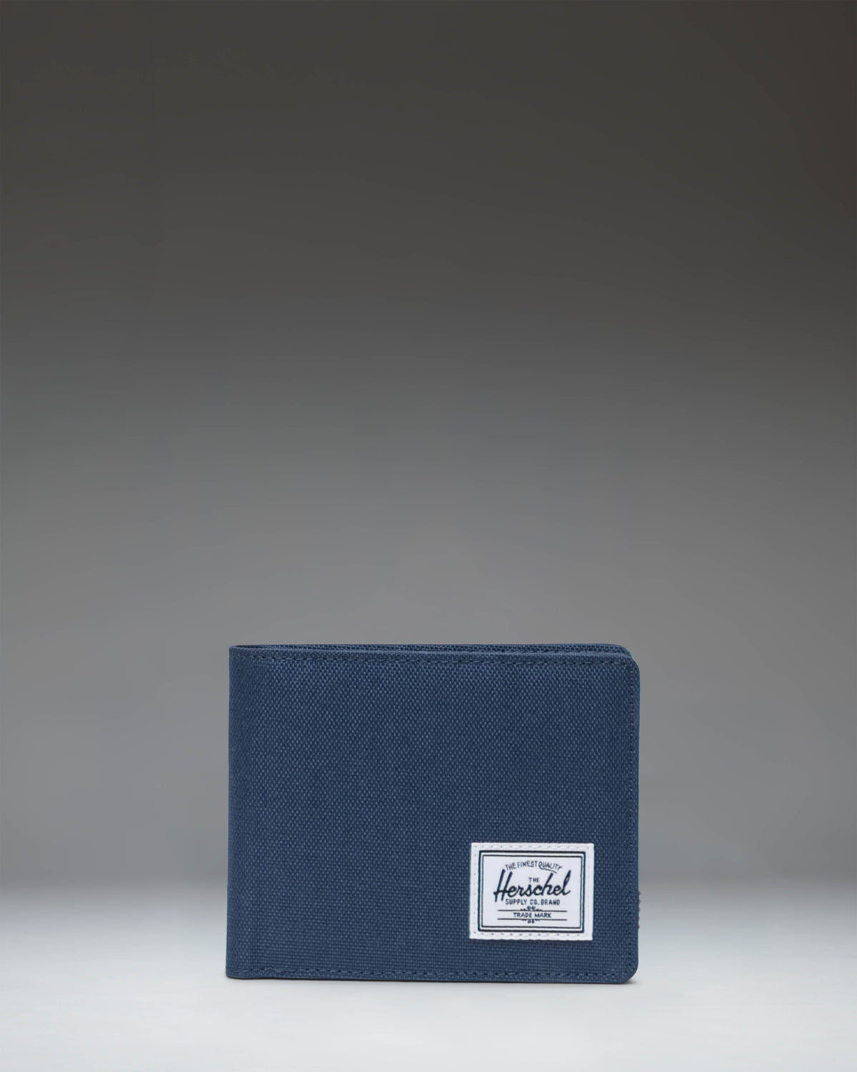 Herschel Supply Co. Roy Coin Wallet in navy blue, showing an open view with card slots and a coin pocket.