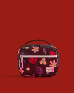 Herschel Supply Co. x LEGO Pop Quiz Lunch Box in the Falling Florals print, featuring a black background with colorful LEGO brick flower patterns.
