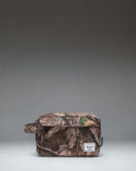 Herschel Supply Co. Realtree Chapter Travel Kit in Realtree APX Camo pattern, featuring a side handle and front zippered pocket.