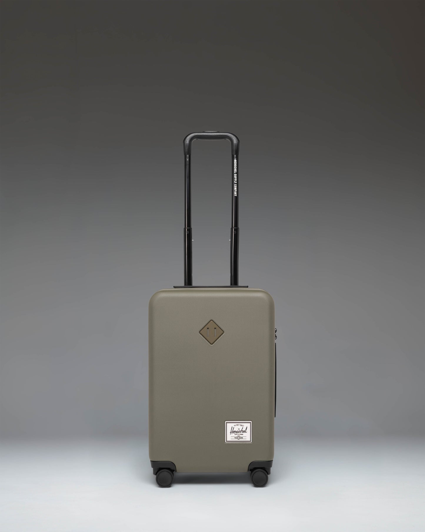 Herschel Heritage Hardshell Large Carry-On Luggage in Ivy Green. Front view showing the durable hard shell and classic design.