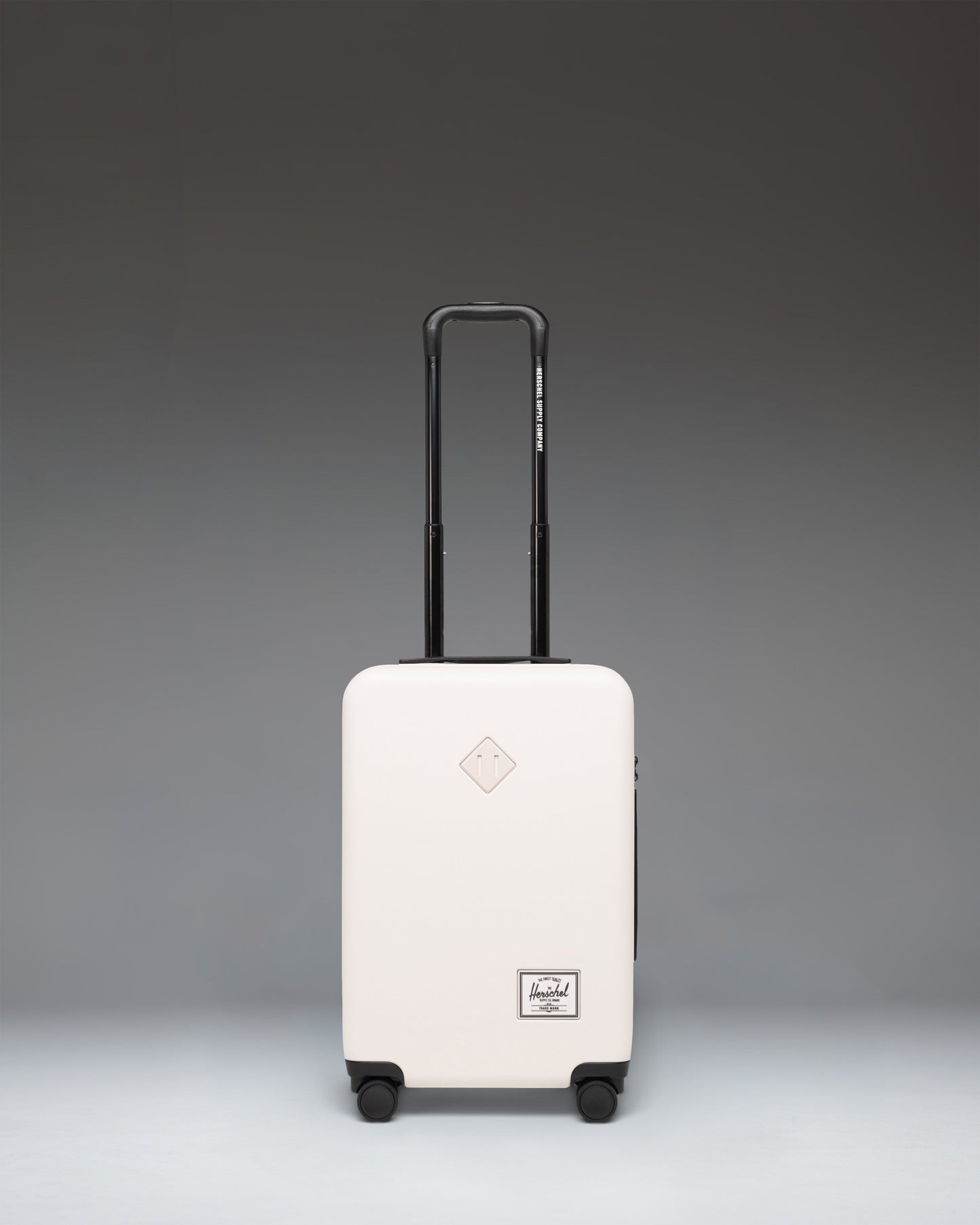 Herschel Heritage Hardshell Large CarryOn Luggage in Moonbeam, a cream-colored rolling suitcase with a textured exterior.