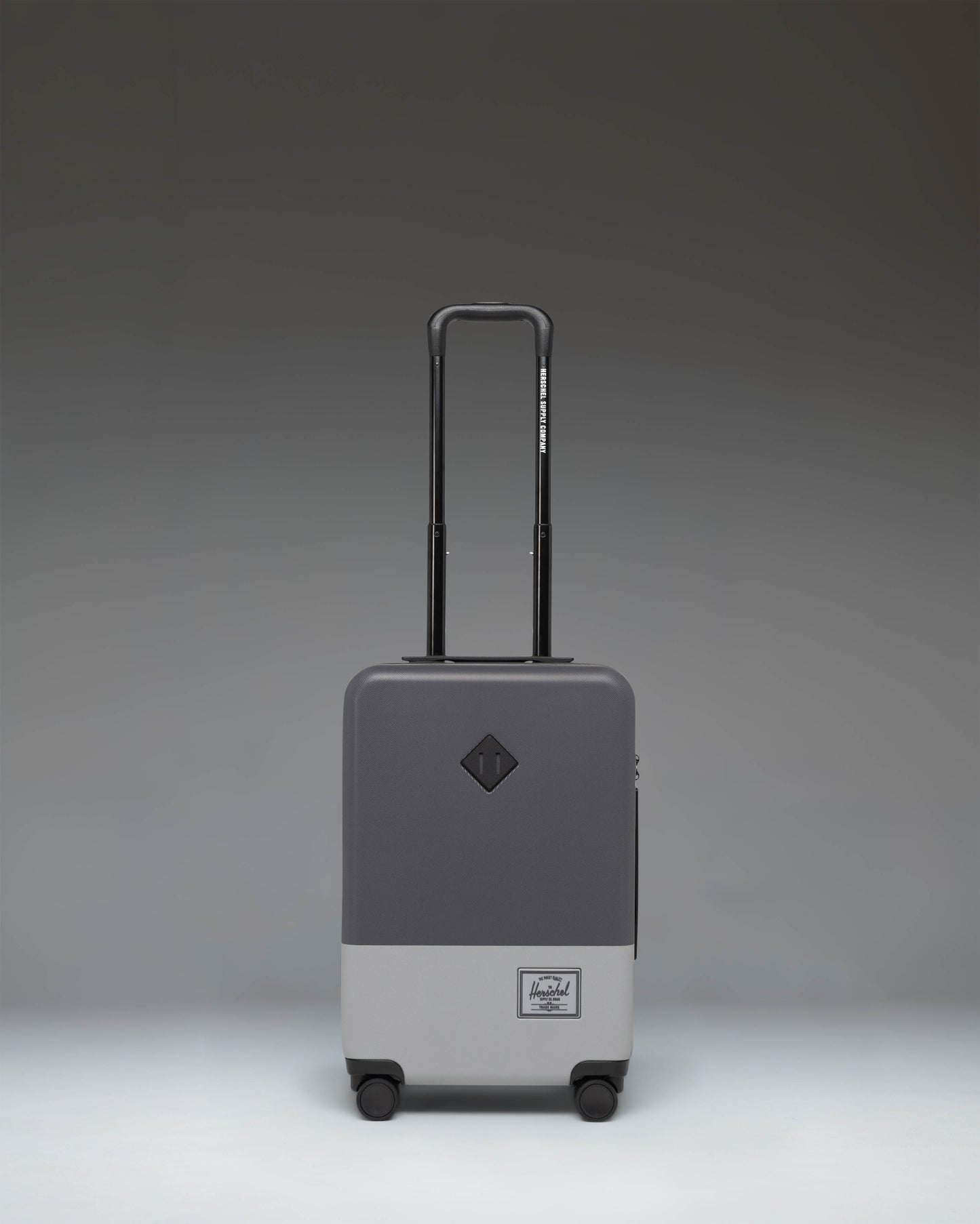 Herschel Heritage Hardshell Large CarryOn Luggage in Blocked Gray, showing the front view of the durable wheeled suitcase.