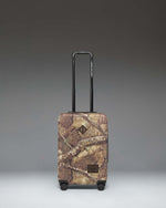 Herschel Heritage Large Carry-On Luggage in Realtree APX Camo pattern, showing the front view of the hard-shell suitcase.