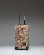 Realtree Herschel Heritage Medium Luggage in Realtree APX Camo pattern, a rolling suitcase featuring a distinct woodland camouflage design.