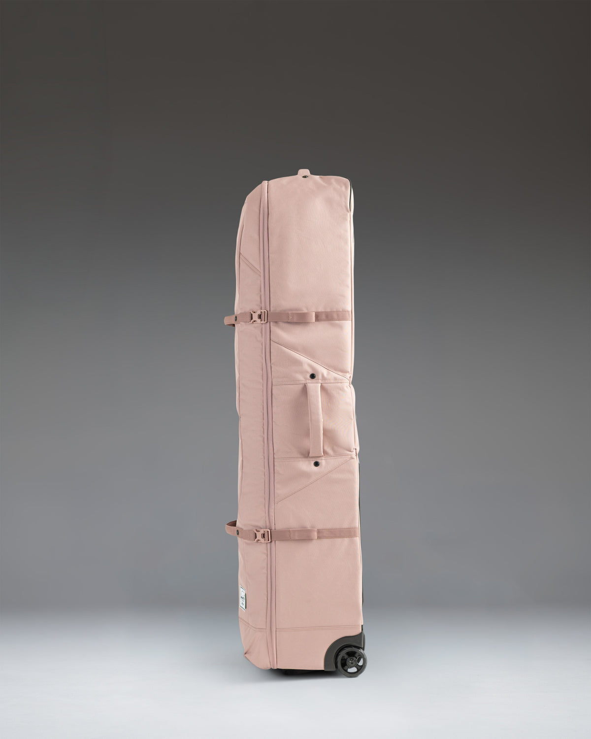 Herschel Heritage Golf Travel Wheelie Bag in Ash Rose, a durable rolling travel bag designed for protecting golf clubs and gear.