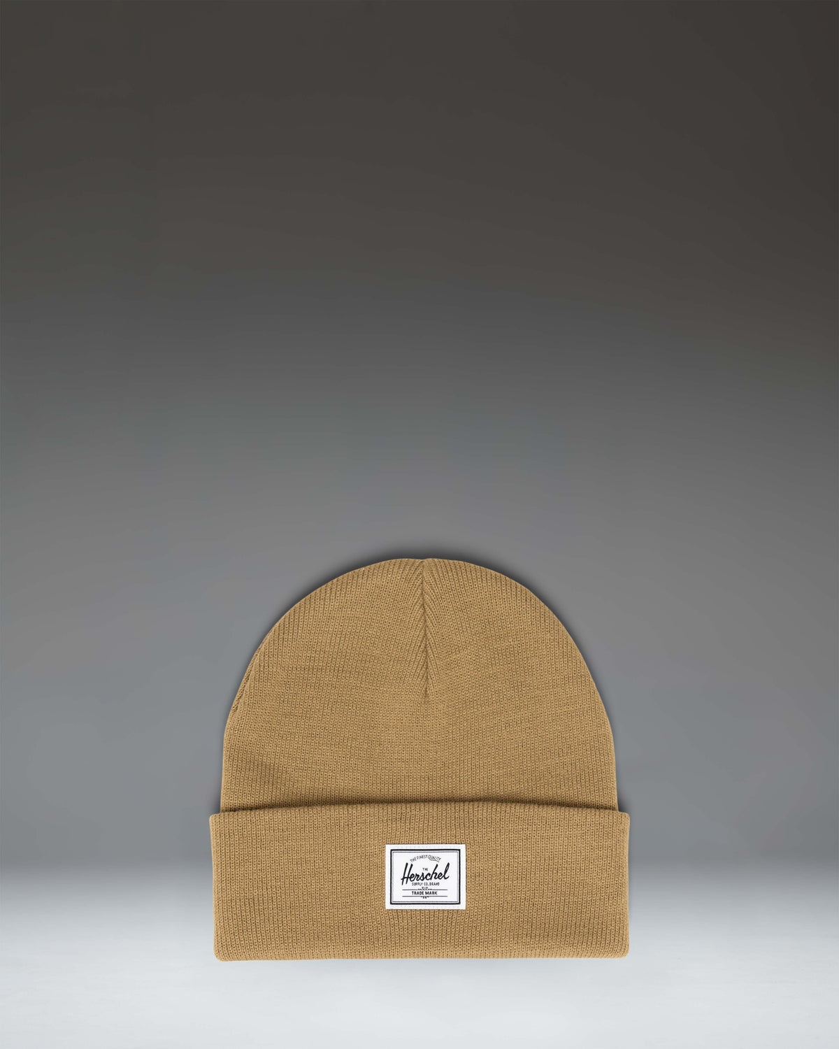 Herschel Supply Co. Elmer Beanie in Antique Bronze brown, showing the classic cuffed knit hat design with a white woven logo label on the front.