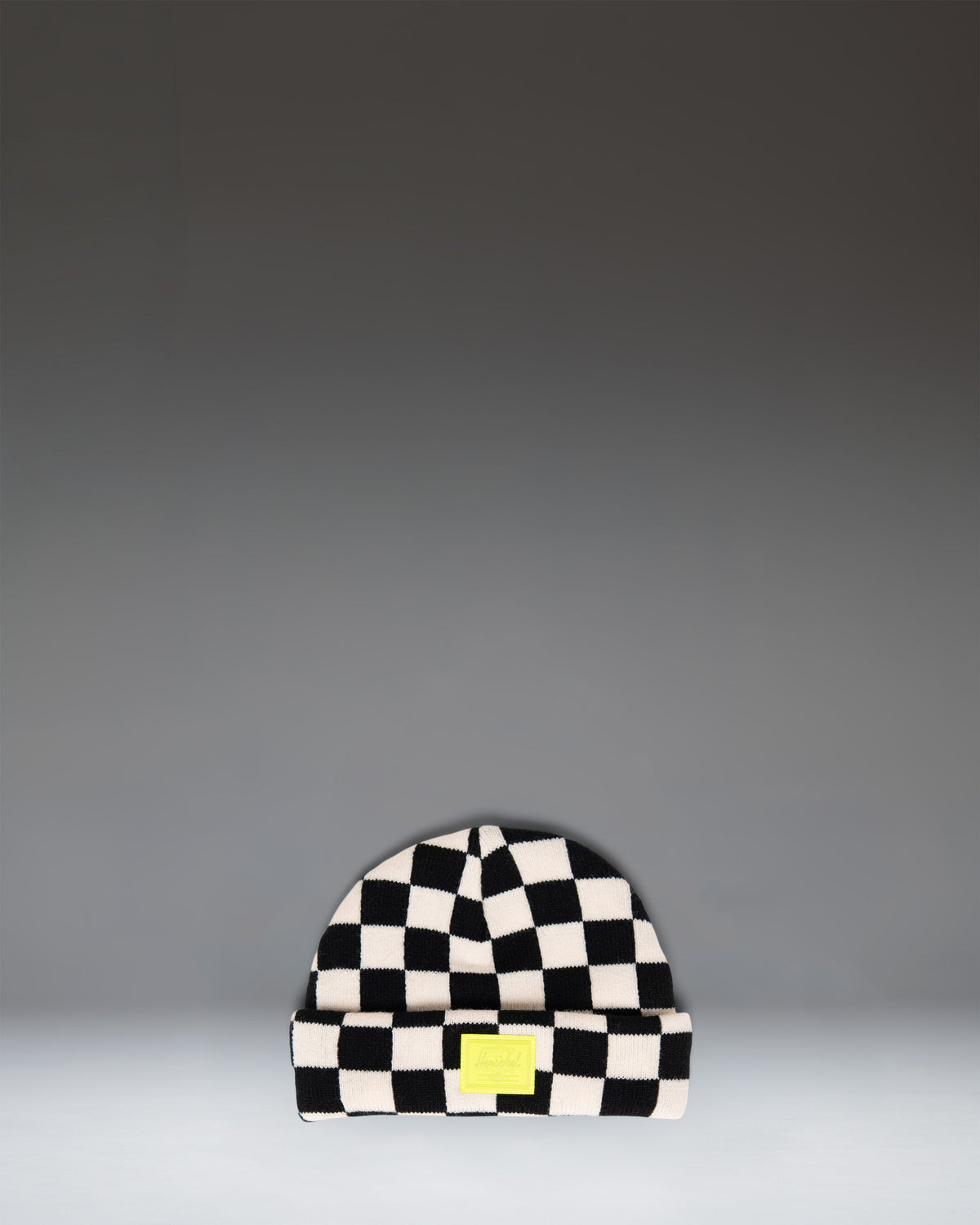 Herschel Supply Co. Elmer Baby Graphic Beanie 0–6 Months in a black and white checkerboard pattern.