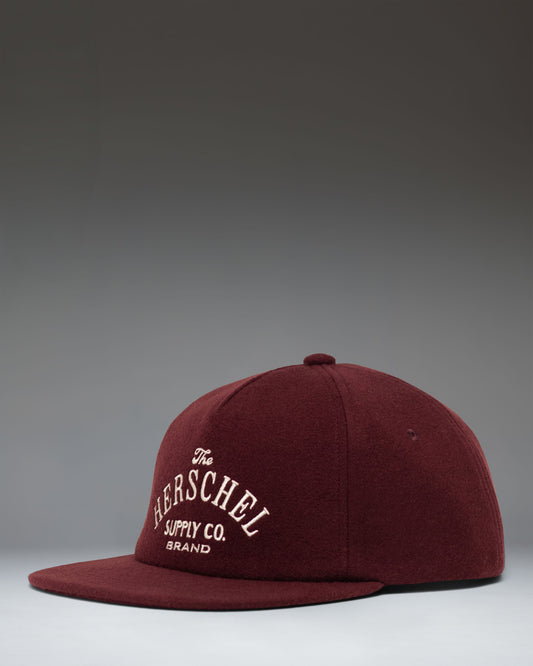 Herschel Supply Co. Scout Heritage Cap in Port, a deep burgundy red baseball hat featuring the classic white woven logo label on the front.