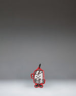 A miniature Herschel backpack bag charm in Tango Red featuring a front pocket, classic logo, and a snap hook for attaching to bags.