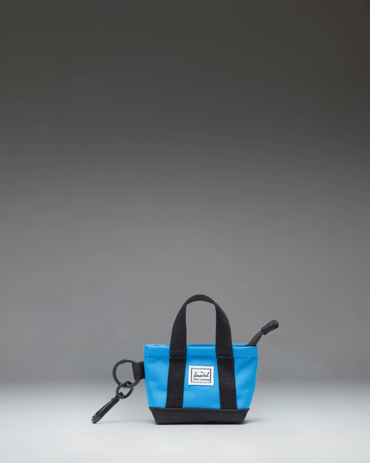 Herschel Heritage Tote Bag Charm in French Blue, showcasing a miniature tote design with top handles and a classic woven label.