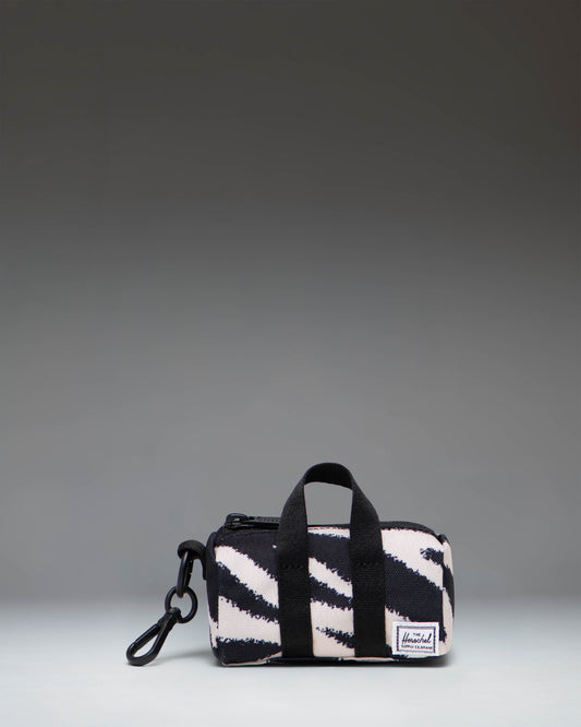 Herschel Novel Duffle Bag Charm in black and white zebra print with a top handle, zippered main compartment, and signature shoe compartment.