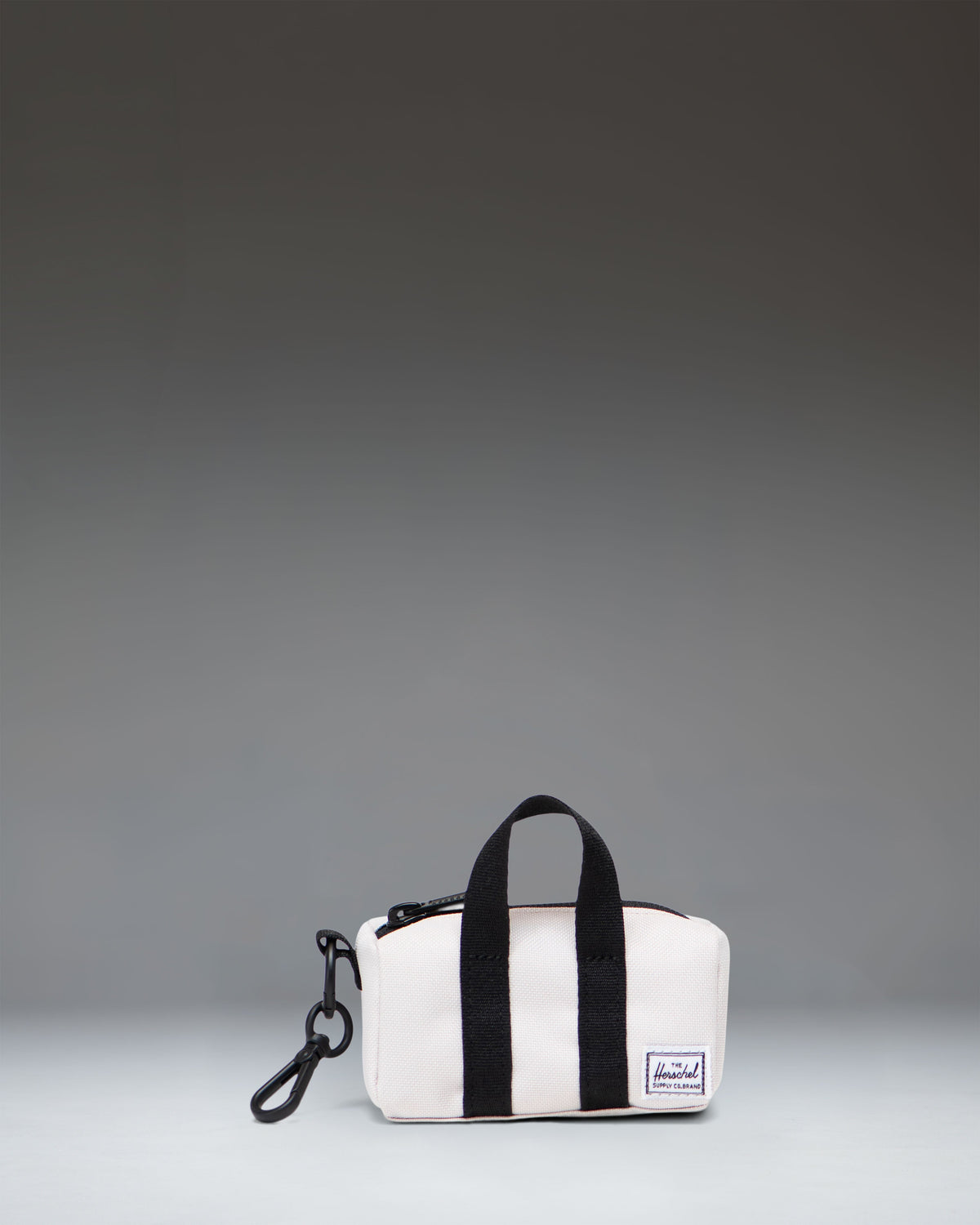 Herschel Novel Duffle Bag Charm in the light beige Moonbeam color, showing a miniature version of the classic duffle bag.