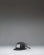 Herschel Supply Co. Sylas Classic Cap Bag Charm in black, showing the front view of a miniature baseball cap keychain accessory.